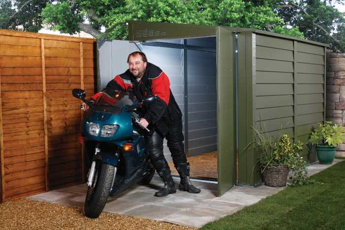 A man takes his motorbike out of a protect a bike storage system Trimetals